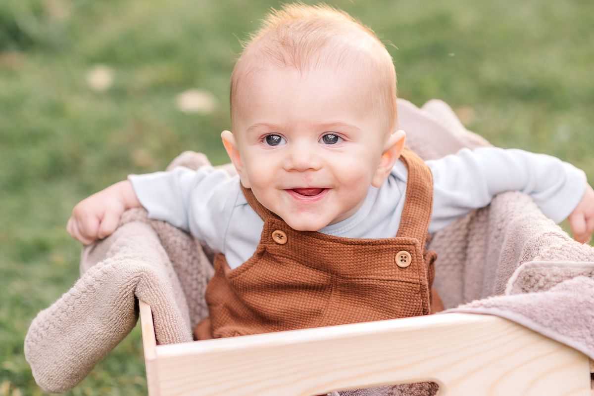 Baby sitting in a crate smiling