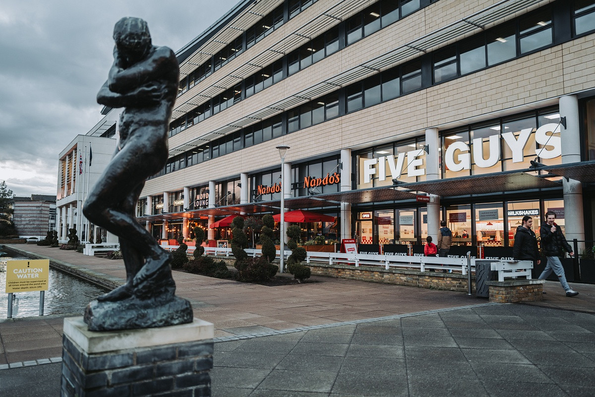 Statue in the water gardens Harlow with five guys in the background