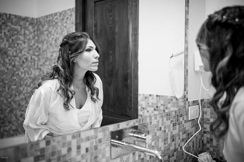 "sposa si guarda allo specchio dopo make up"