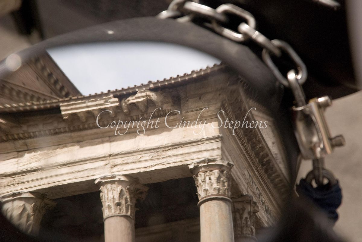 Reflection of columned historic building in motorcycle mirror in Rome