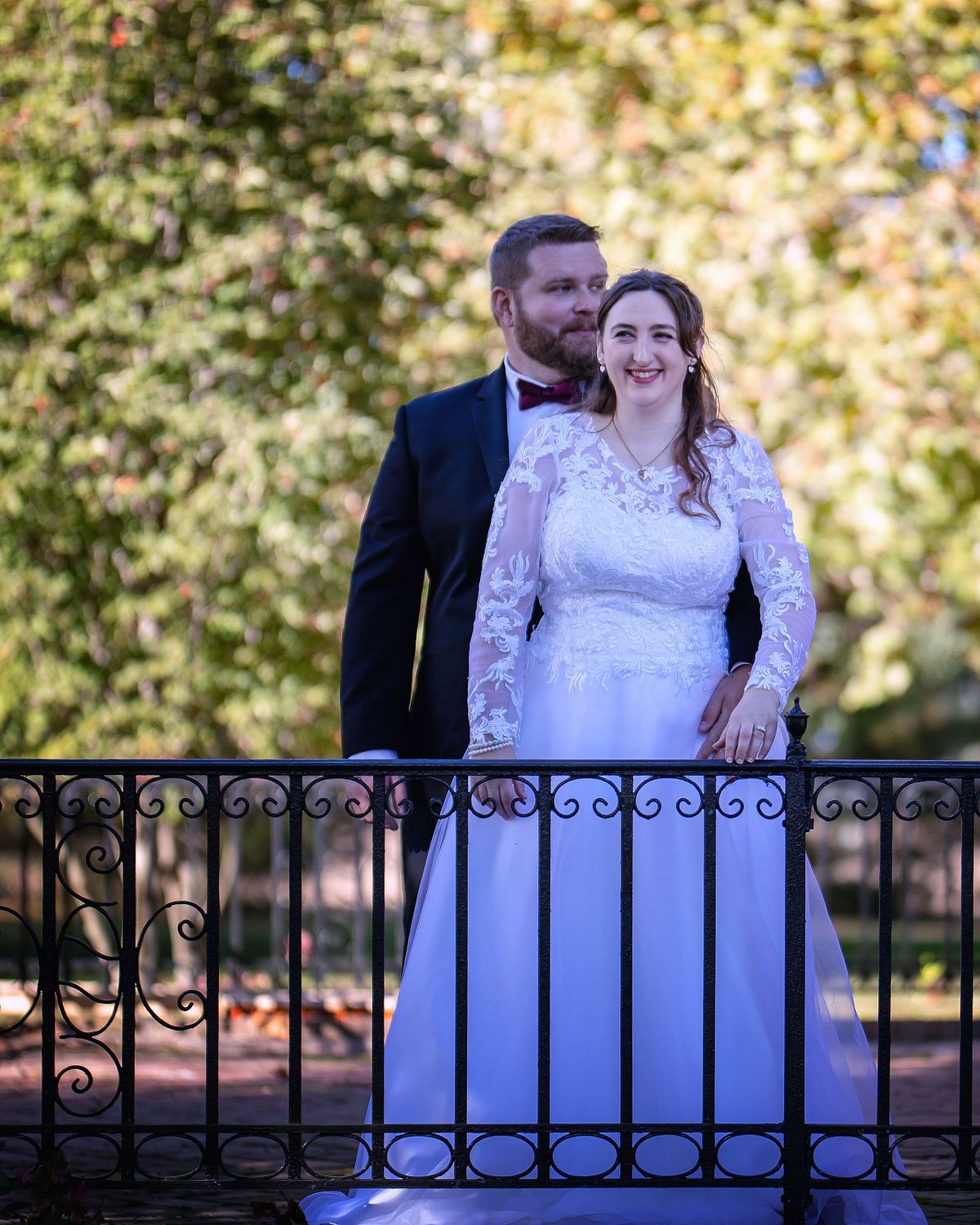 bride and groom standing on the veranda at ross mansion during golden hour wedding portrait session