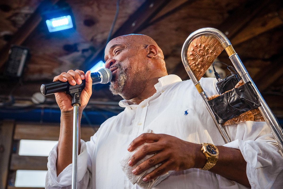 Performance photography capturing Jeff Bradshaw singing and playing trombone during a live music event in Philadelphia, showcasing musical mastery and cultural vibrancy.