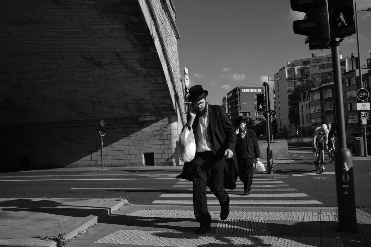 Orthodox Jewish men crossing the street under an overpass, captured by photographer Sandeep Gajula