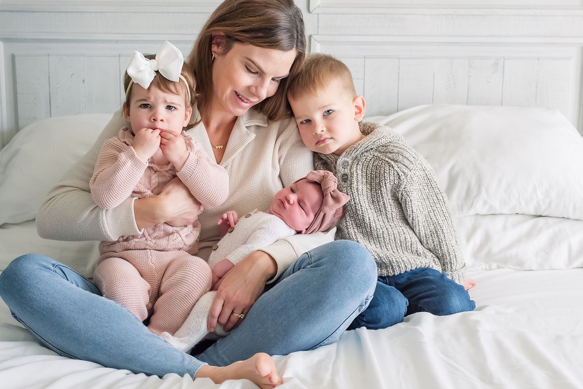 mom on her bed with her two children and newborn baby girl with cranberry township, pa newborn photographer