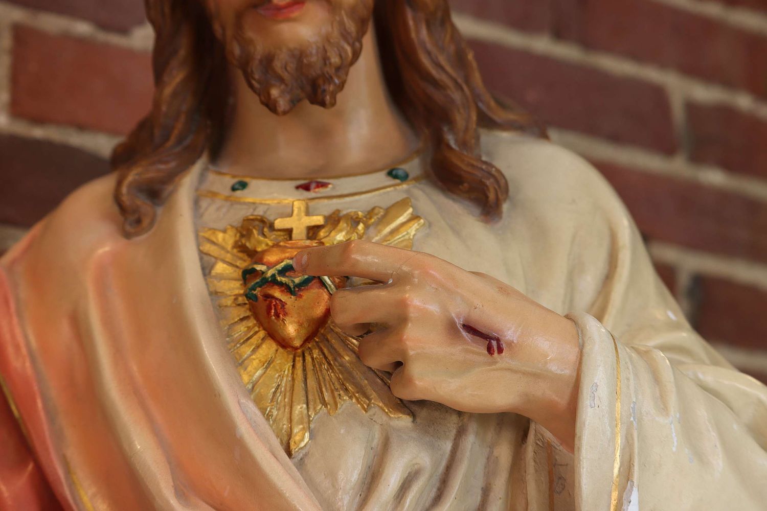 The Sacred Heart painted a fading gold color before restoration