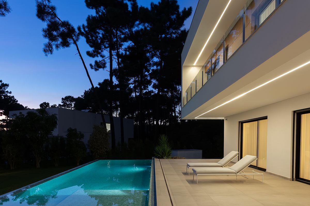 Fotografia de moradia contempor&acirc;nea na Herdade da Aroeira com piscina e ilumina&ccedil;&atilde;o noturna