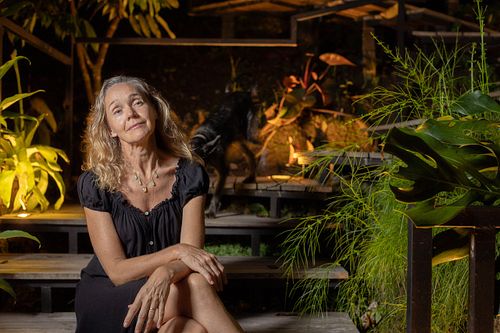 Smiling woman in a black dress posing with two dogs on outdoor steps at night, photographed by Mats Karlsson.