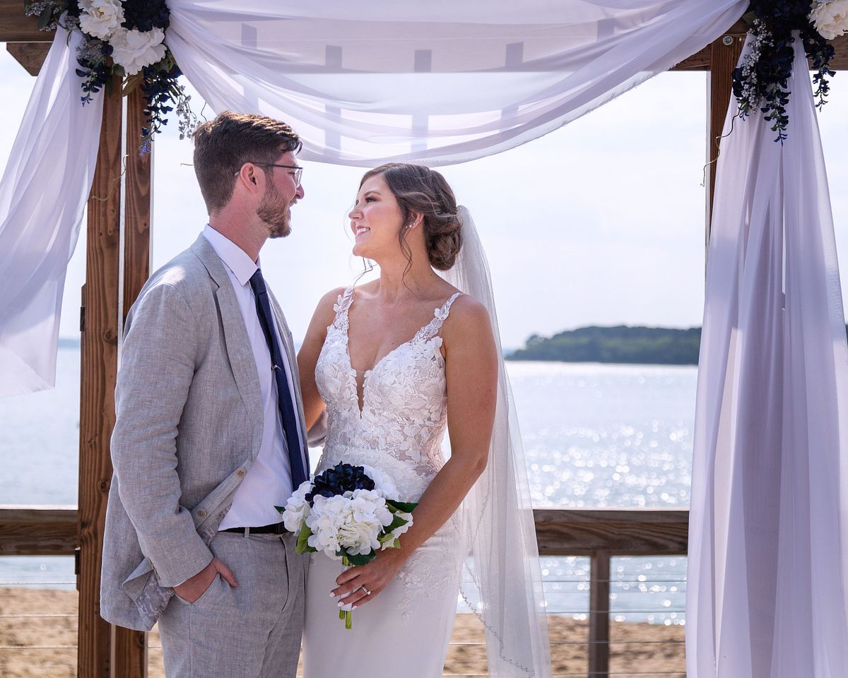 a bride and groom after the ceremony under the wedding arch in dewey beach, sussex county, de