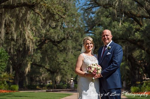 A sophisticated mature bride and groom embracing during their second marriage ceremony in a lush Florida garden setting.