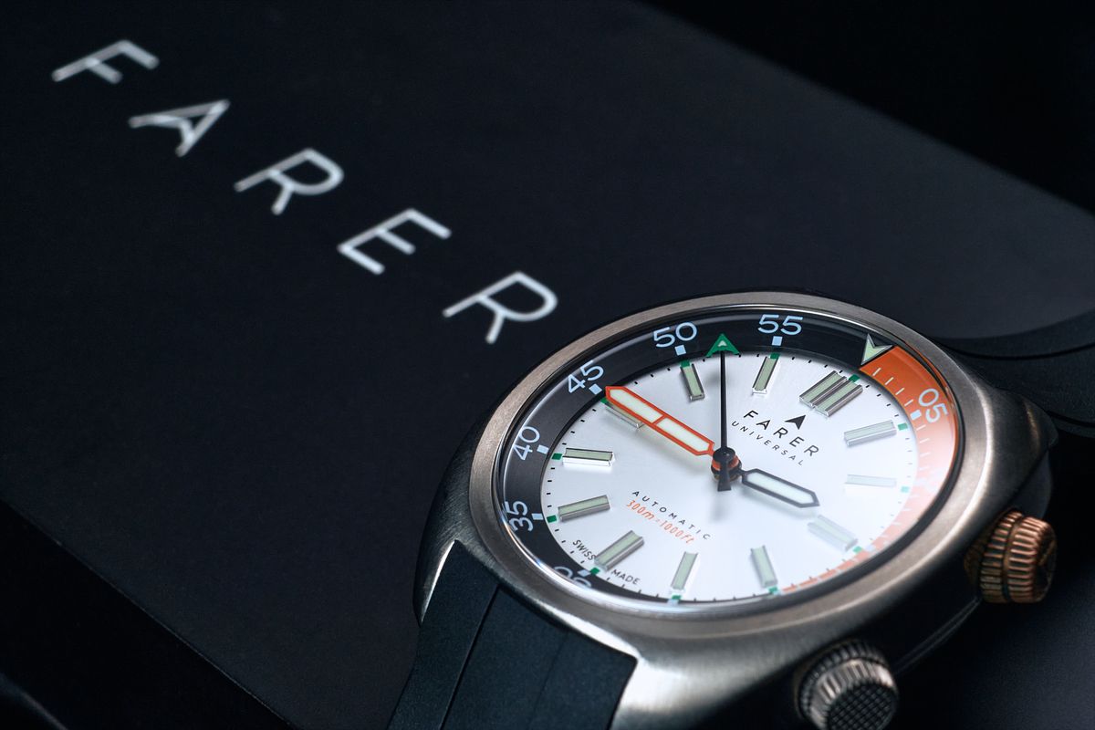 Mechanical dive watch sitting on a black colored and branded box.