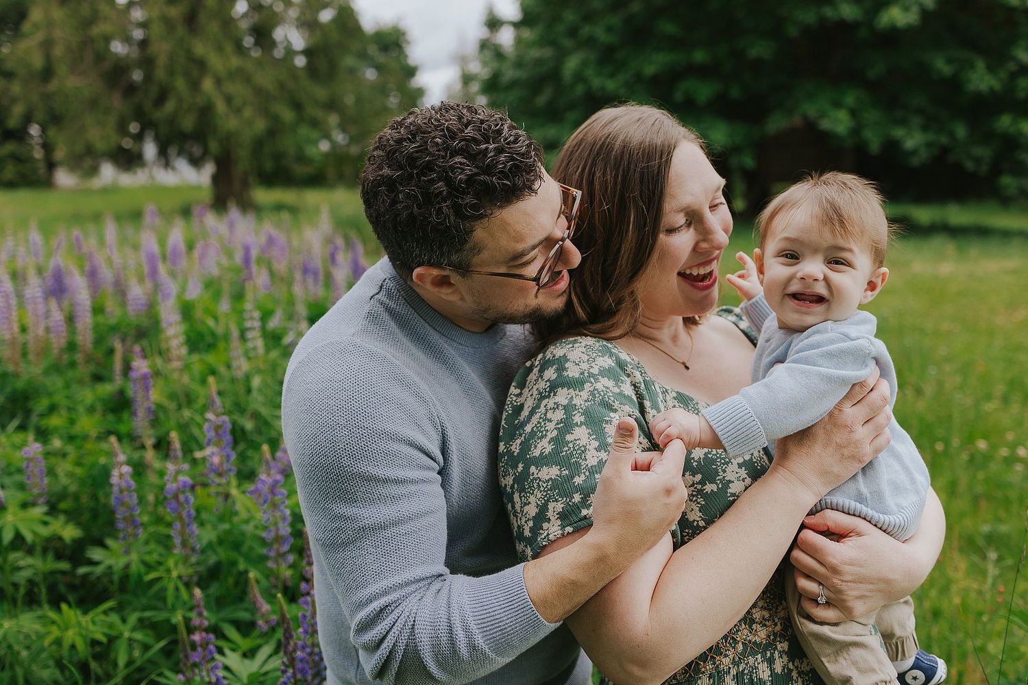 A family smiling by a field of flowers