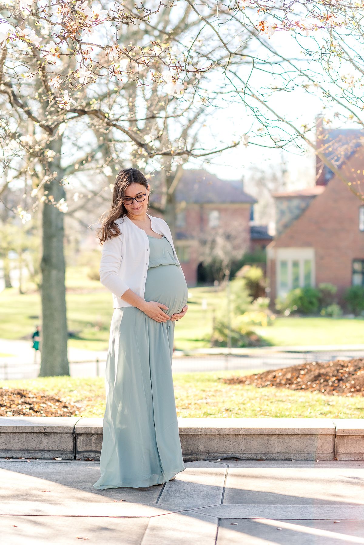 Pregnant mom standing near The Frick Museum in sunset light