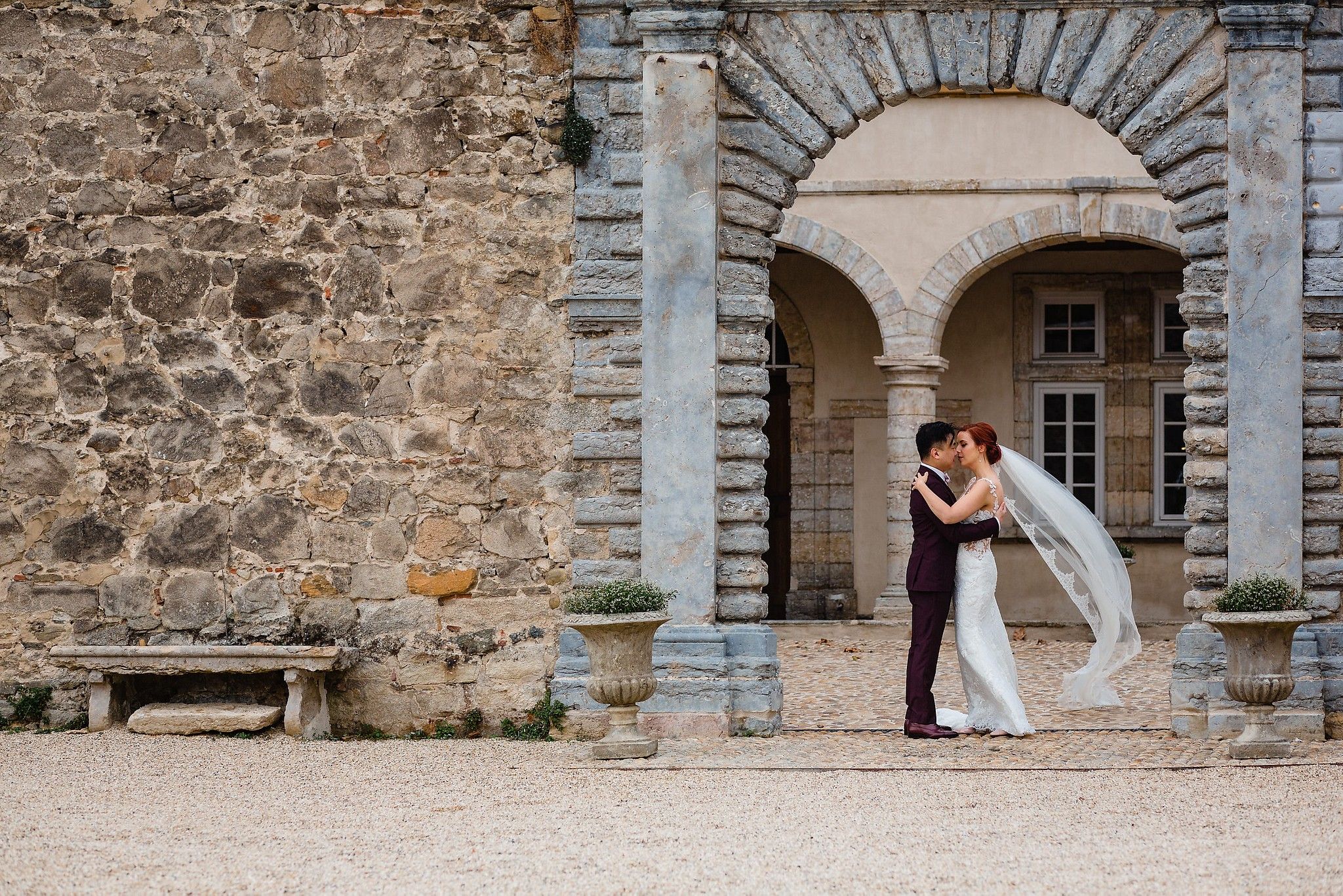 Portrait de mari&eacute;s qui s'embrassent devant l'entr&eacute;e du Ch&acirc;teau la Gall&eacute;e captur&eacute; par S&eacute;bastien CLAVEL photographe de Mariage &agrave; Lyon et Gen&egrave;ve