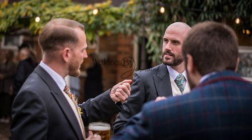 A group of friends gathered and chatting during the wedding reception, enjoying the celebration together, captured by Weddings By Jermaine.