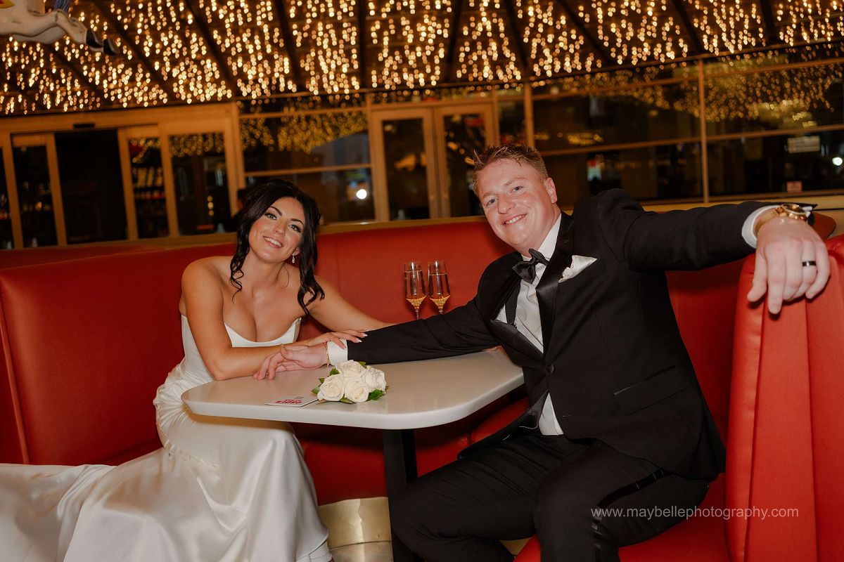 Romantic elopement photos at Carousel Bar in Downtown Las Vegas with couple celebrating with champagne