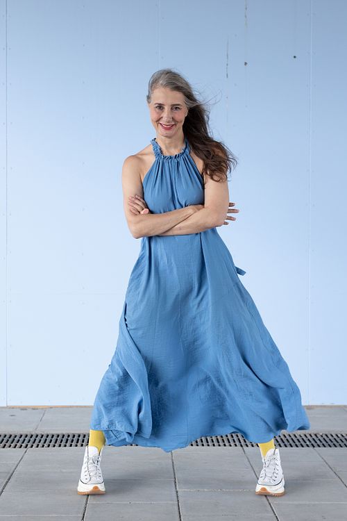 Woman in blue dress smiling, environmental portrait Stockholm
