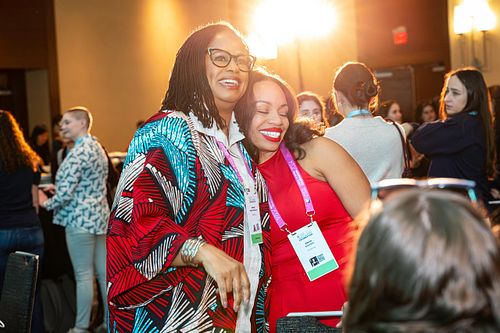 Brenda Darden Wilkerson embraces an attendee during a joyful networking moment at the Grace Hopper Celebration 2024.