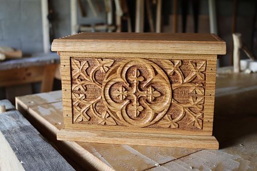 an oak box with Gothic quatrefoil, vines and leaves carved by hand to hold bourbon glasses