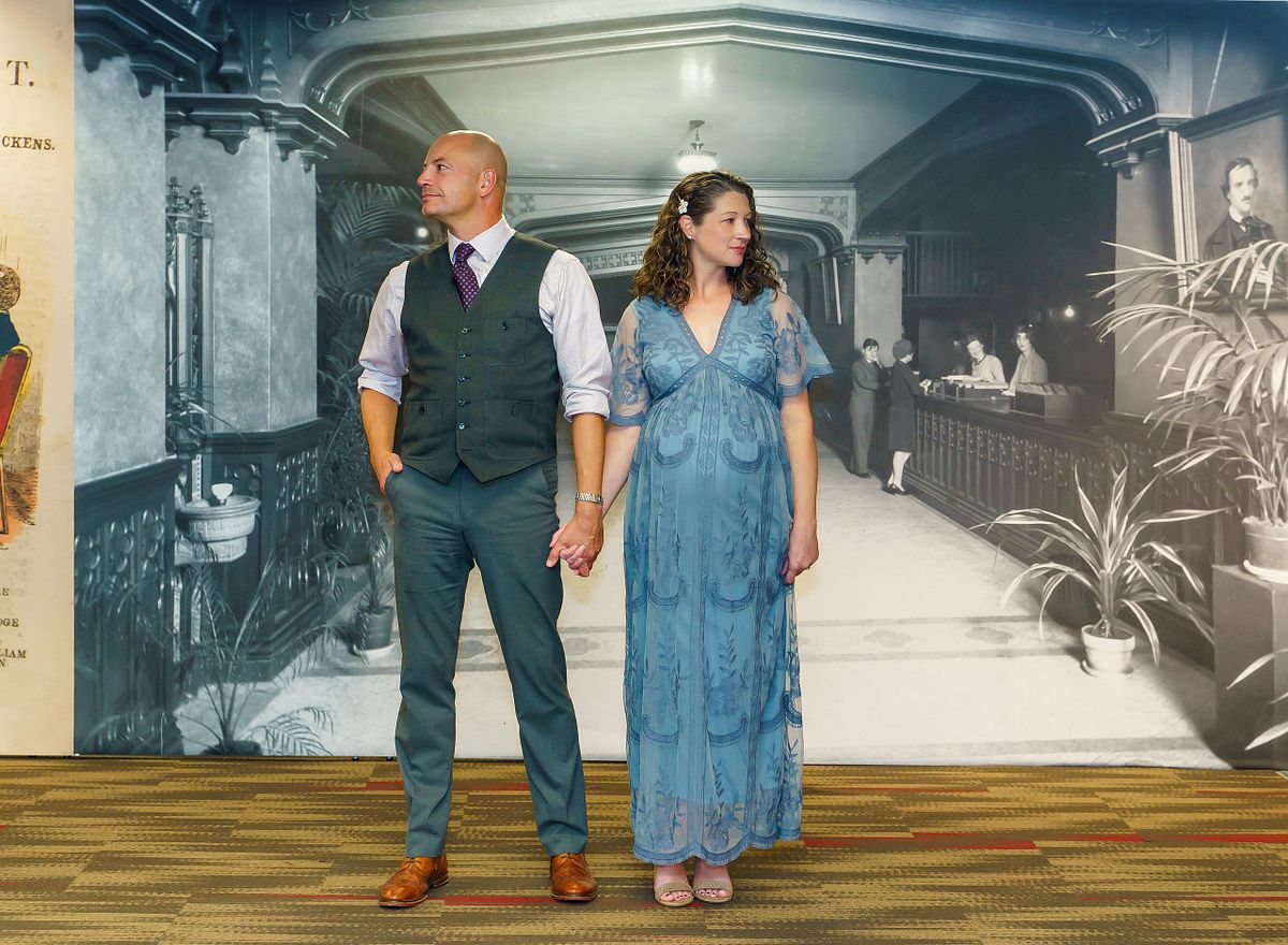 Pregnant woman posing in natural light with a flowing maternity gown.