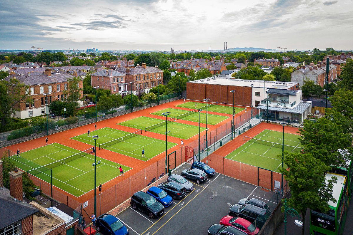 Elevated photograph of the tennis courts at Brookfield Tennis Club, Dublin, with a view of the surrounding area.