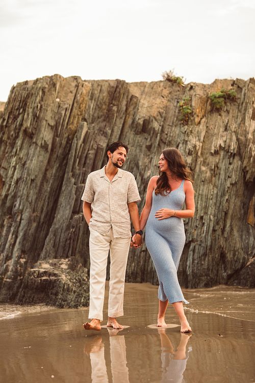 coppia in gravidanza cammina nel bagnasciuga di Masua in Sardegna, Fotografo Gravidanza Cagliari Sud Sardegna