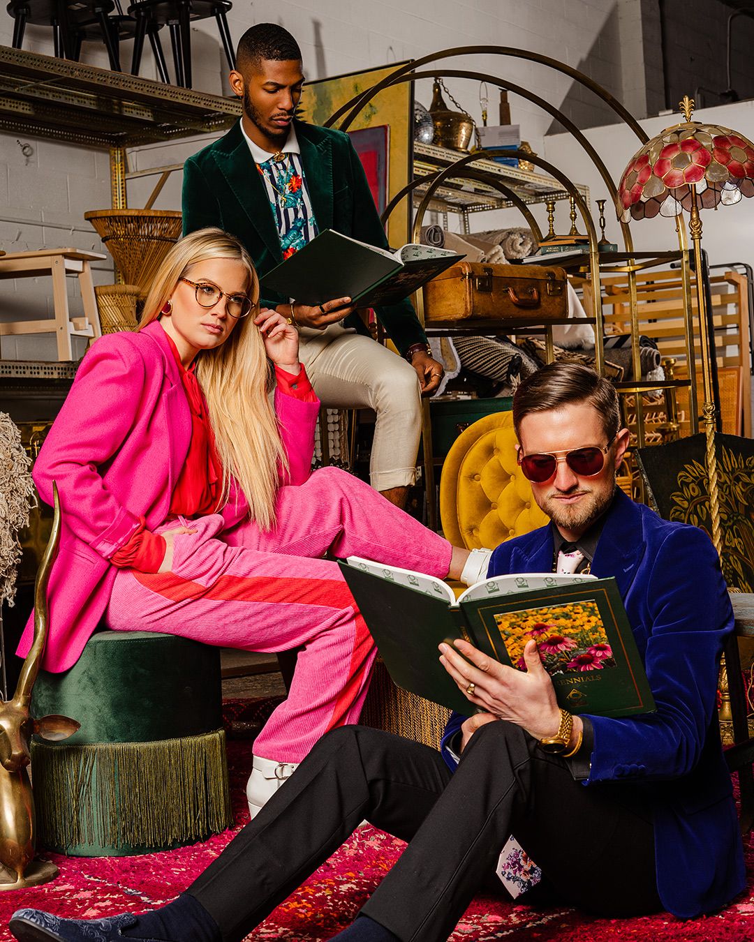 Brightly colored portrait of three models inspired by a Gucci campaign photographed surrounded by furniture and antiques in a warehouse.