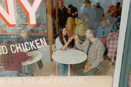 a couple sharing an ice cream shot through a window
