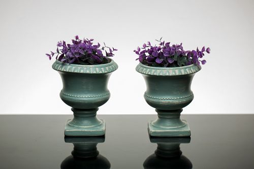 Green decorative pots with vibrant purple flowers, ideal for home decor