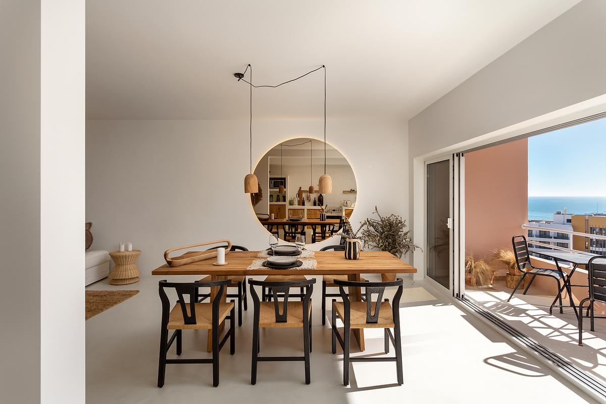 Sala de jantar de apartamento T2 na Guia em Cascais com liga&ccedil;&atilde;o visual ao exterior e vista mar