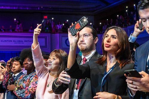 Audience members hold up phones to capture a powerful moment during the Future of Funding session at CGI 2024.