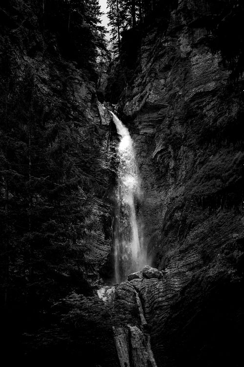 Cascade en noir et blanc, cadrage vertical serré.