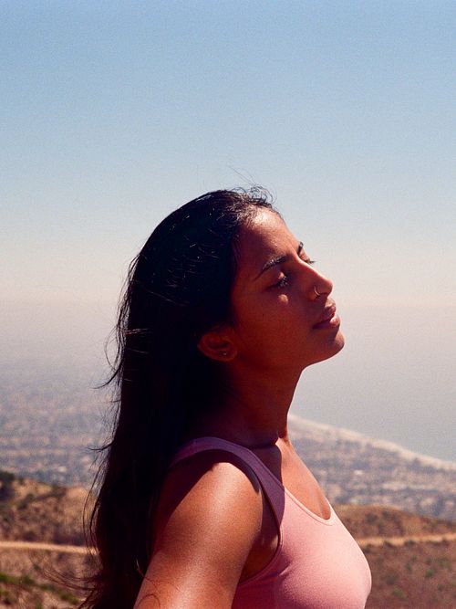 Indian woman looks at sky ocean background