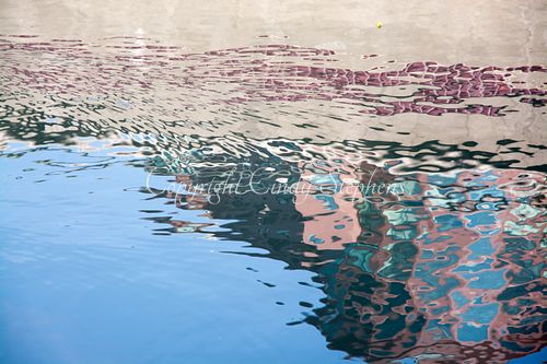 A building shimmers in water creating impressionistic pink shapes and forms