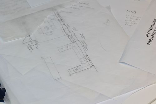 Skisspapper i lager med handritad plan och anteckningar – inredningskoncept under utveckling.