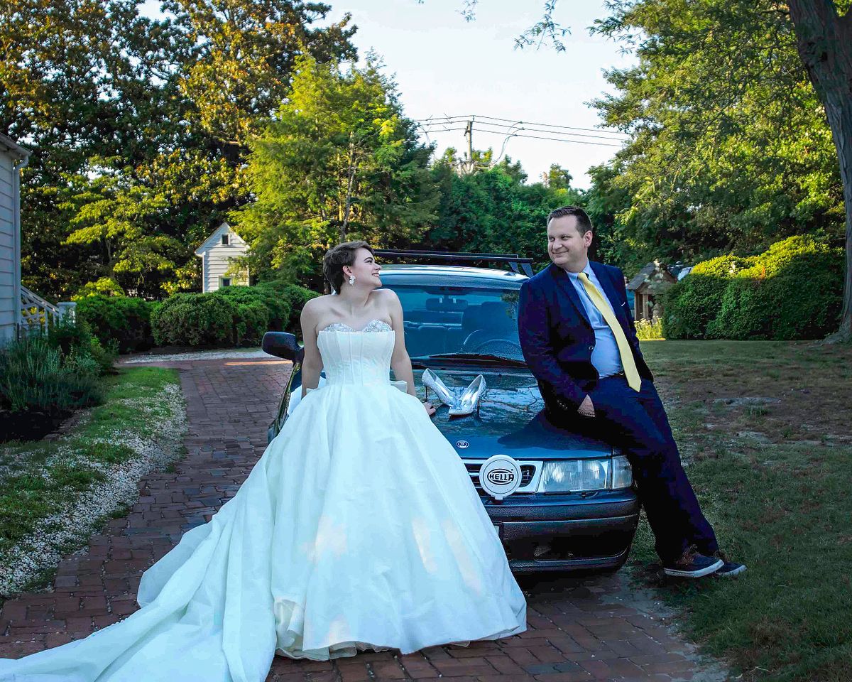 bride and groom on hood posing on the hood of their car at polar Hill mansion Salisbury  md