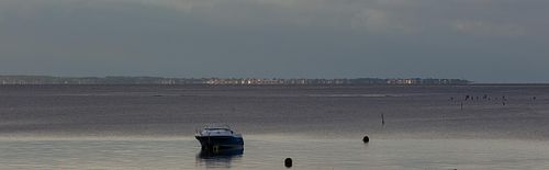 Bateau au mouillage sur plage calme.