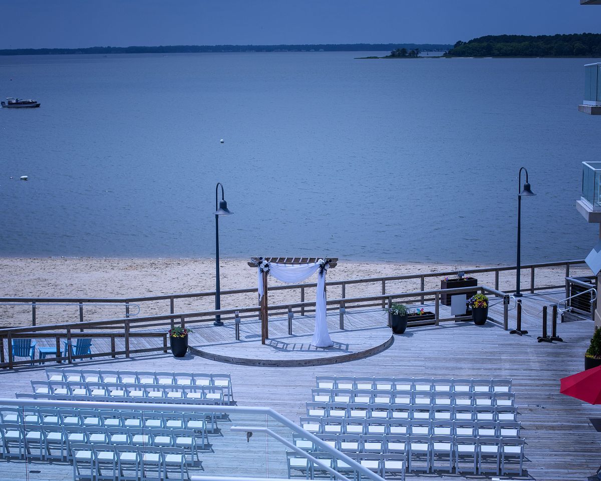 arial view of ceremony site before any guests arrive, the sun is bright, the water a deep blue, the scene is over the Rehoboth bay
