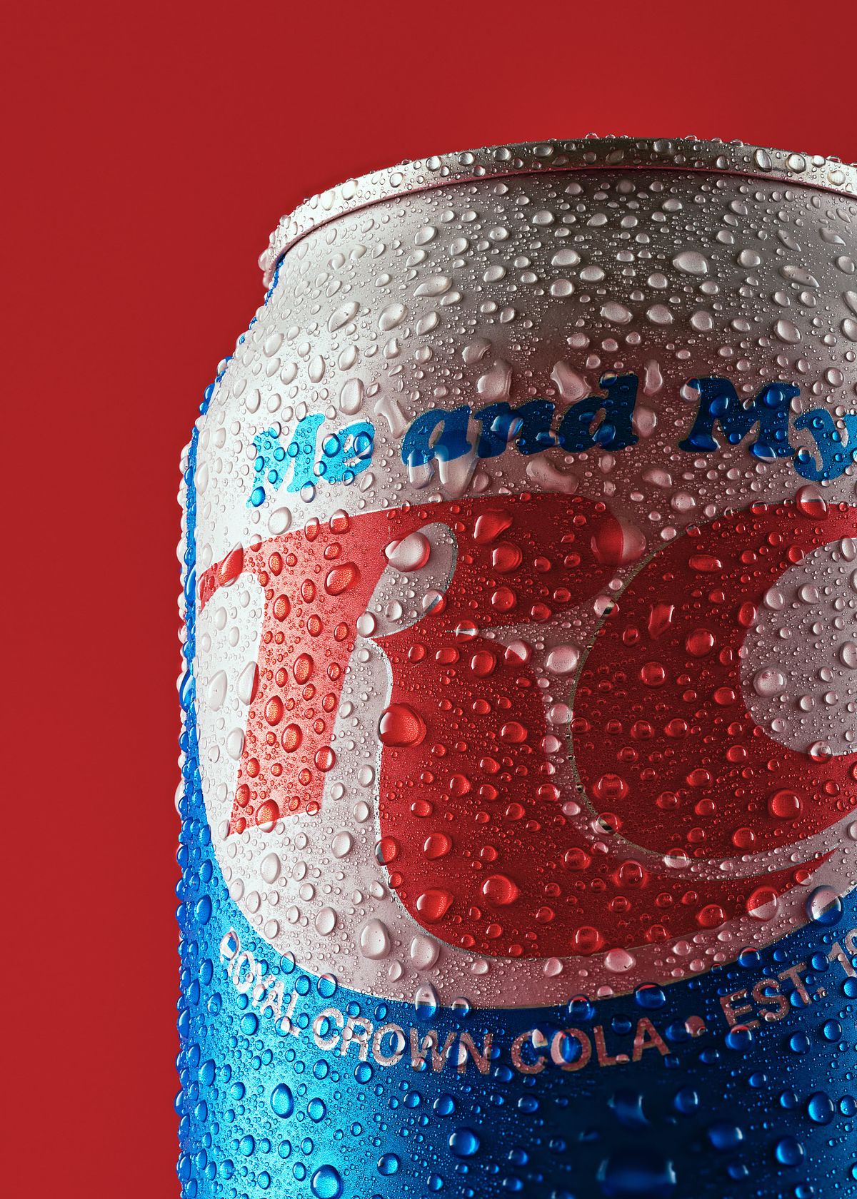 Close up hero shot of an ice cold cola can in front of a bold, red backdrop.