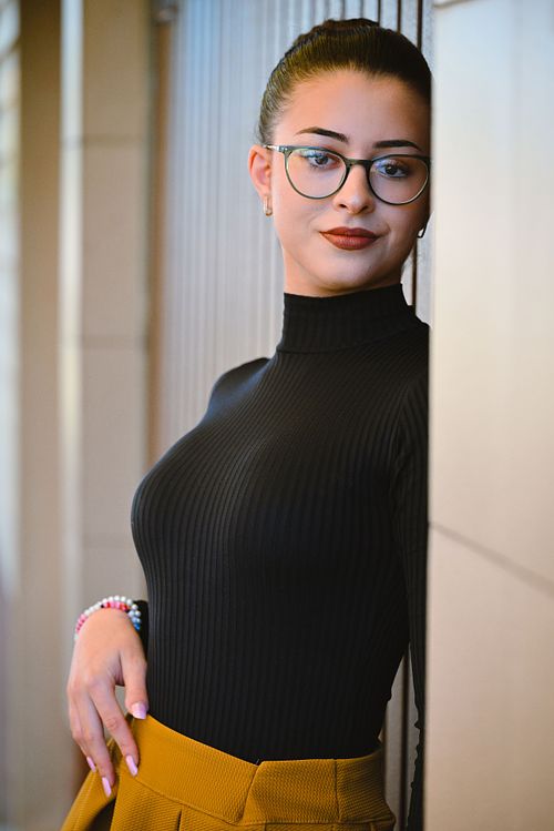 portret feminin elegant cu ochelari și fundal arhitectural