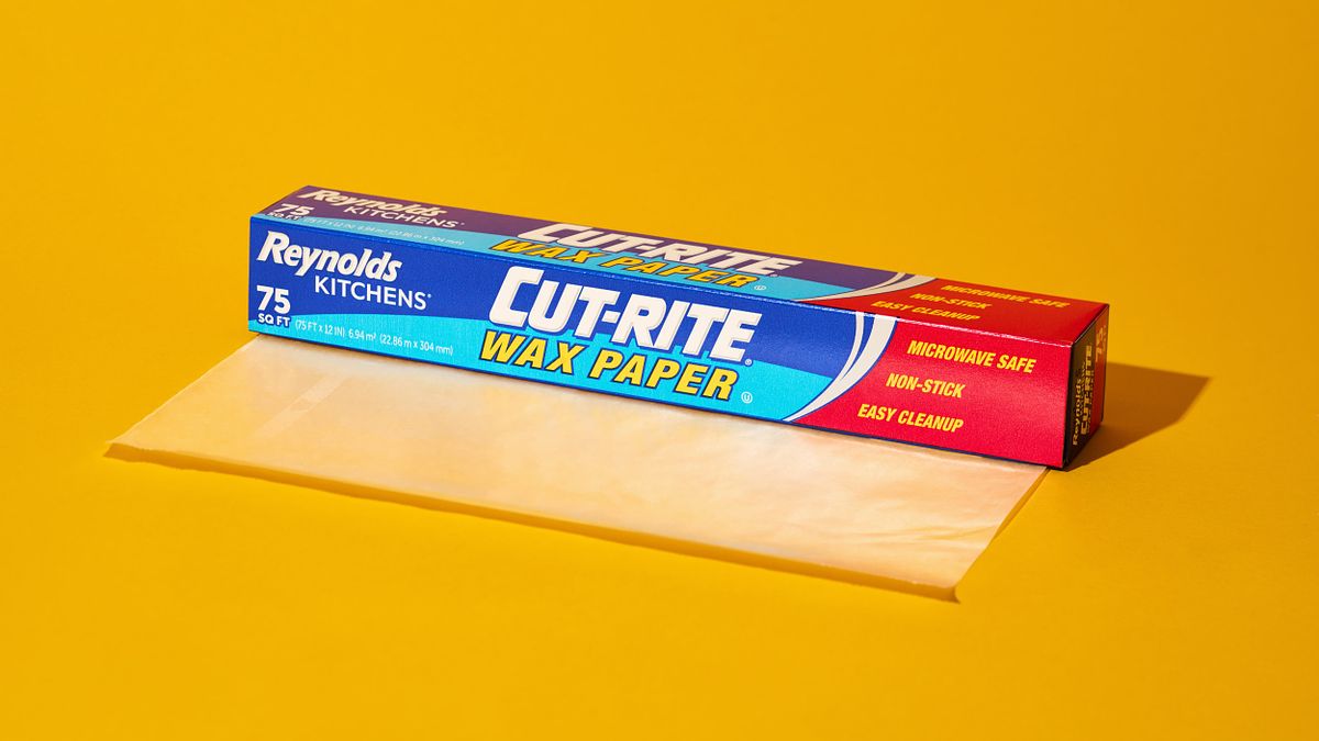 Blue and red box of wax paper on a bold yellow surface.