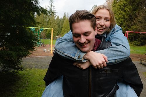 couple having fun as girlfriend catches a piggy back ride