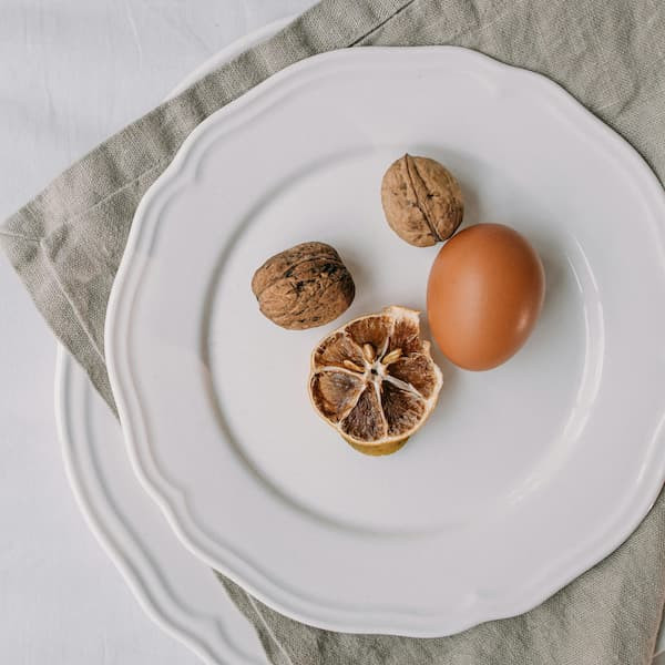 plate with a hard boiled egg and walnuts