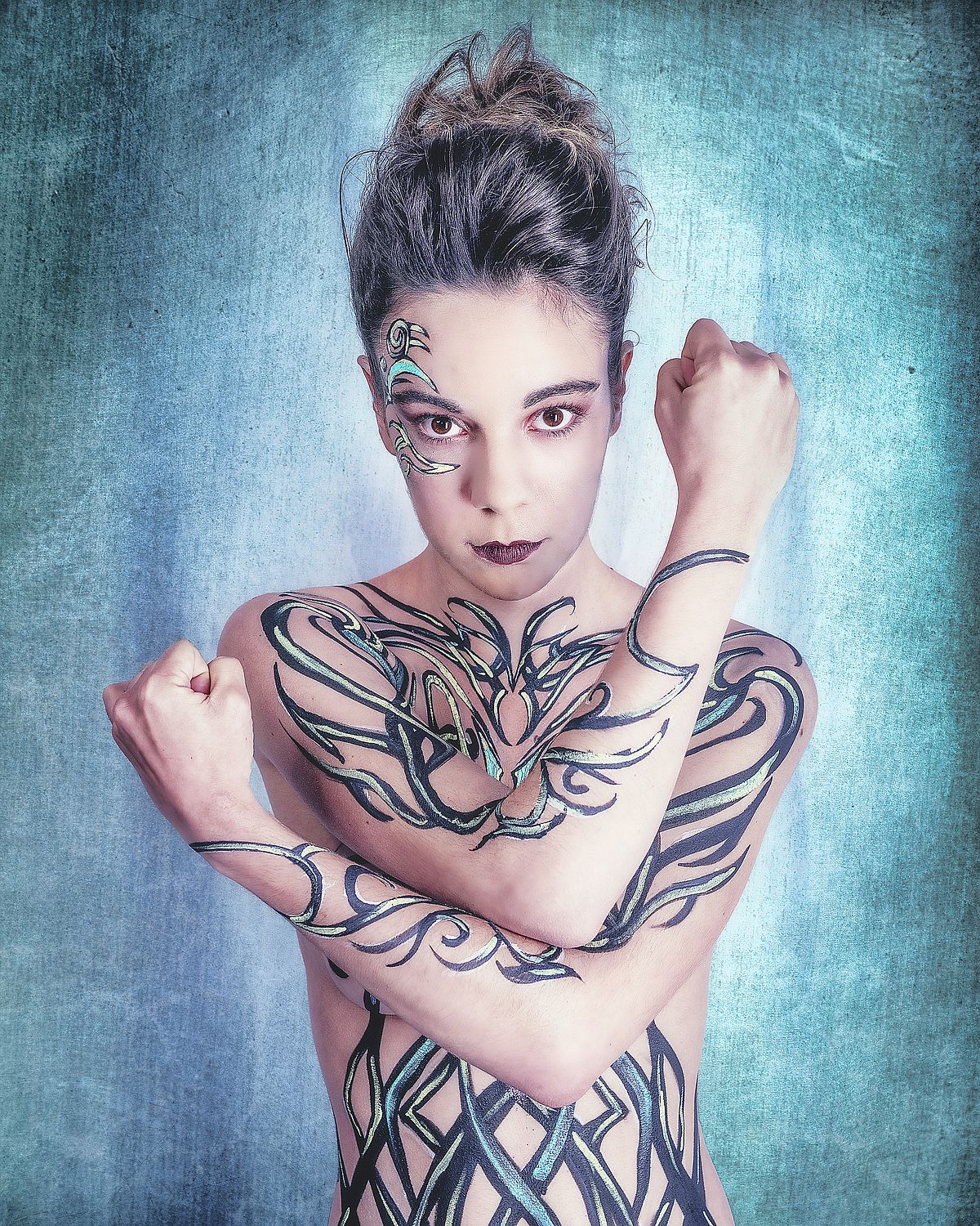 photo tarot Light Warrior, femme nue bras crois&eacute;s avec lignes peintes sur le corps et fond bleu lumineux