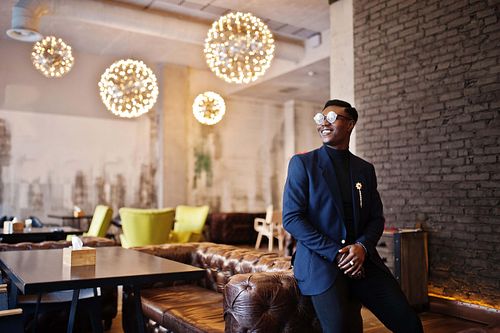Fashionable african american man in suit and glasses posed at ca