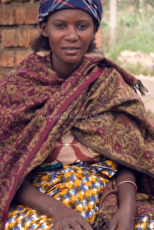 Paulina, dressed in vibrant traditional clothing, sitting in the market in Arusha, Tanzania, showcasing the rich cultural heritage.