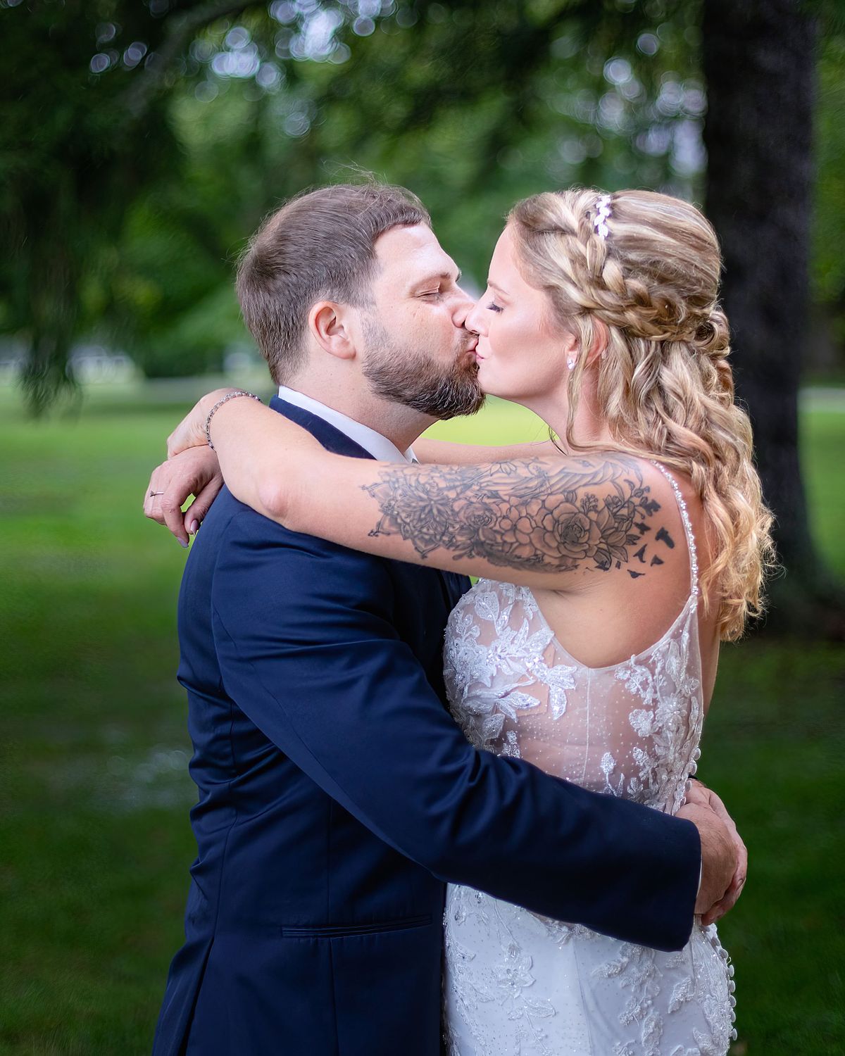 posed photo of bride and groom kissing under the trees at ross station