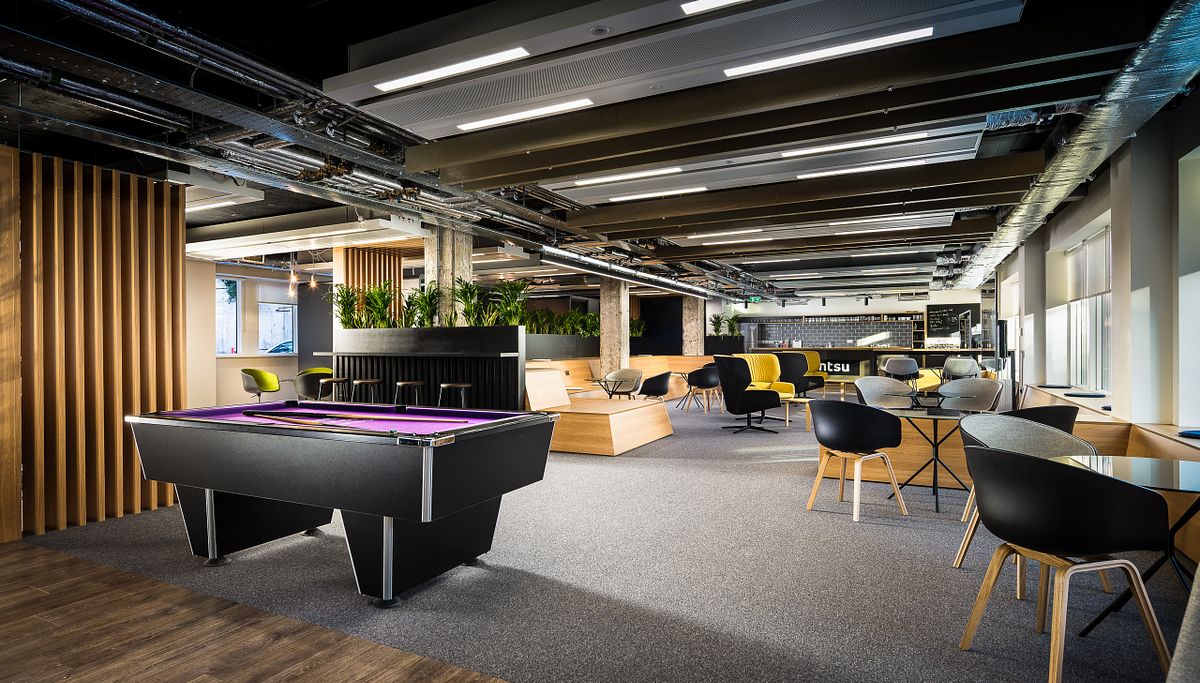 Office canteen and breakout area with pool table, wooden fins, and varied seating.
