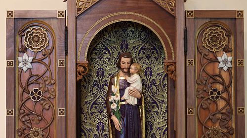 Beautiful statue of Saint Joseph and the Child Jesus in a shrine that was custom made for them by Wes Baker of Contrasts Woodcarving