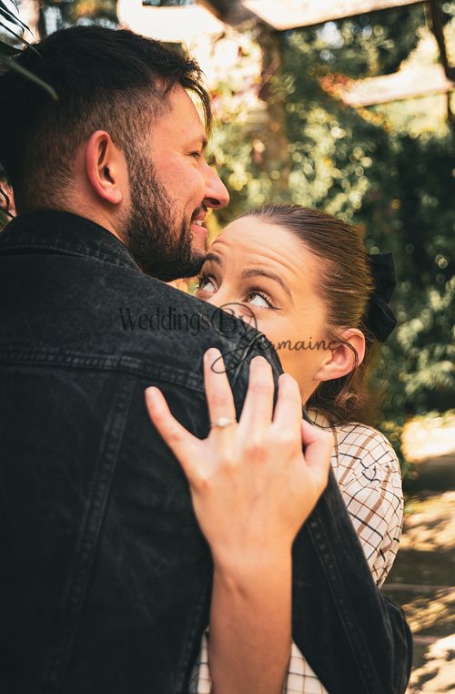 Alex and Shelby hugging during their engagement shoot, with the bride-to-be looking up at her fiancé with wide eyes full of love, captured by Weddings by Jermaine