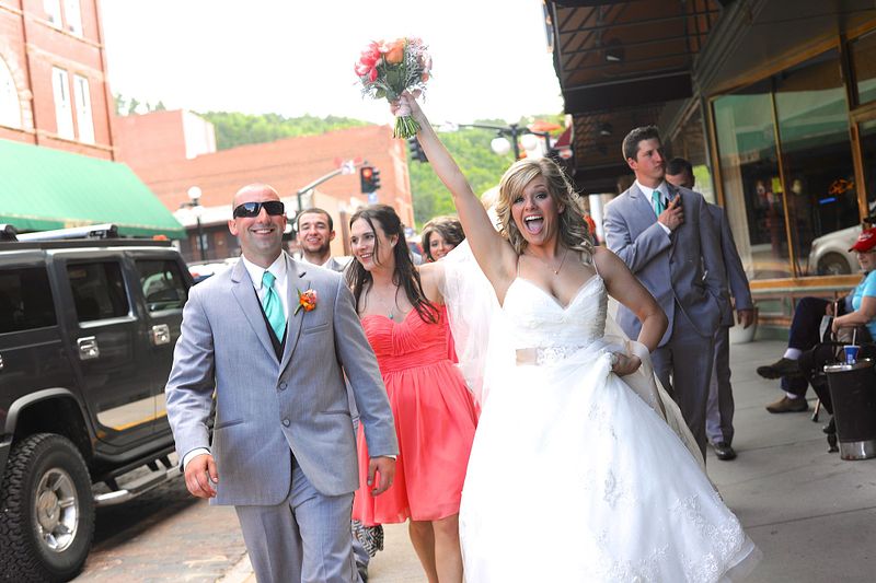 Bride and groom with wedding party celebrating on the street  in Deadwood South Dakota — Black Hills wedding photographer